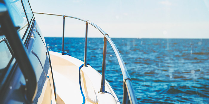 Un bateau glisse tranquillement sur des eaux turquoise sous le soleil éclatant, créant une atmosphère de relaxation et de liberté.