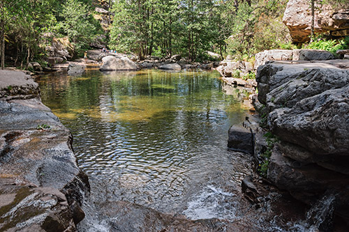 Photo d'une rivière calme entourée d'une nature verdoyante, parfaite pour la détente et la méditation.