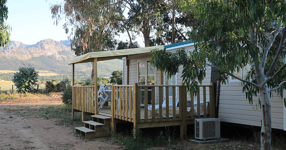 maison-mobile-dans-la-nature-avec-vue-sur-les-montagnes Image d'une maison mobile entourée d'eucalyptus avec une vue panoramique sur les montagnes, idéale pour des escapades en famille ou entre amis.
