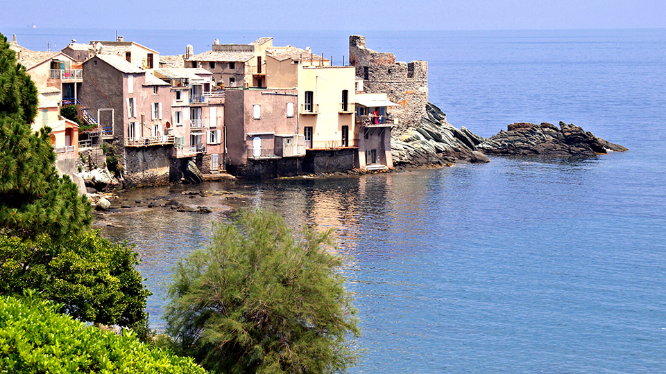Vue enchanteresse sur le village corse d'Erbalunga, avec ses maisons colorées le long de la côte méditerranéenne.