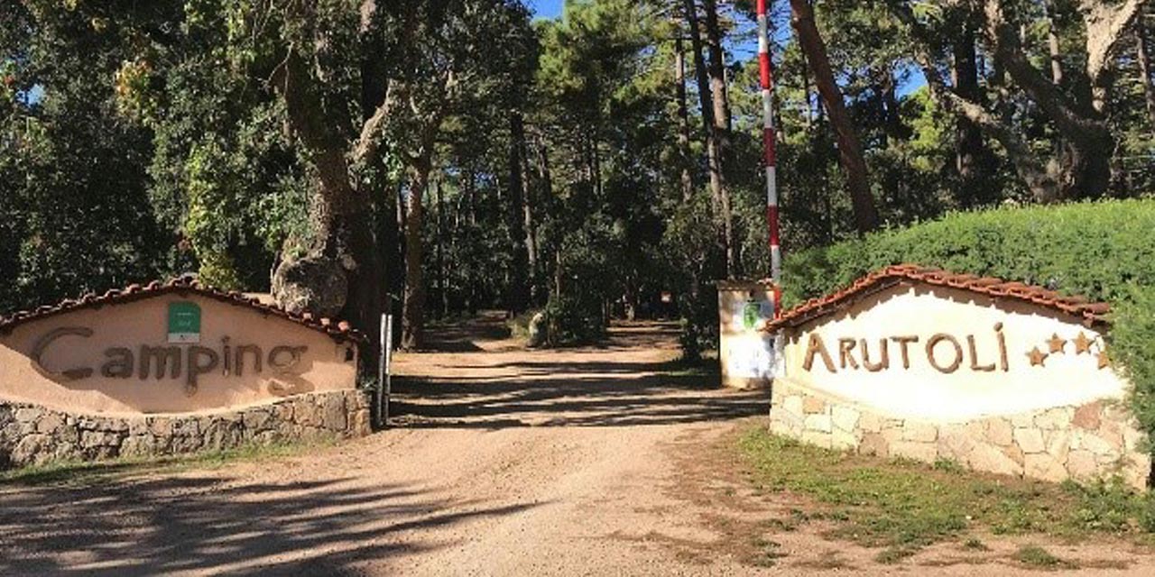 Cette image montre l'entrée du camping Arutoli, entourée de nature luxuriante, invitant à des séjours ressourçants et détentes en plein air.