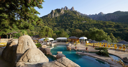 Cadre enchanteur d'une piscine scintillante entourée de montagnes verdoyantes, invitant à l'évasion et à la détente dans une atmosphère de sérénité.