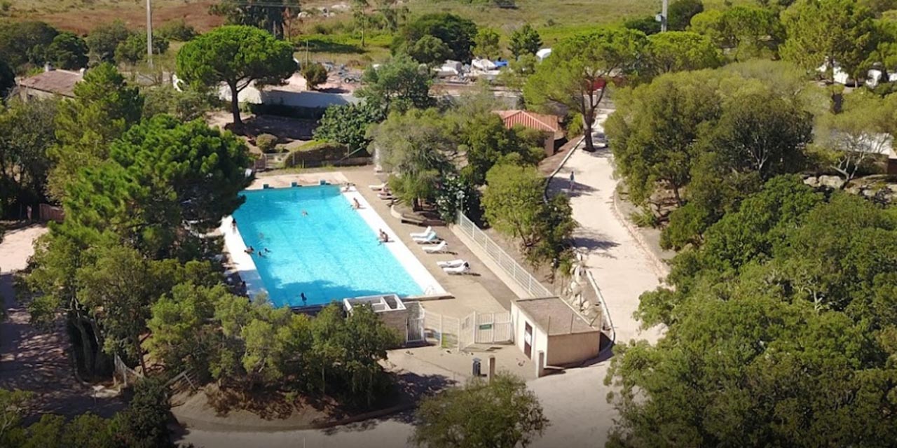 Image de piscine extérieure entourée de nature, parfaite pour la détente estivale et les loisirs aquatiques.