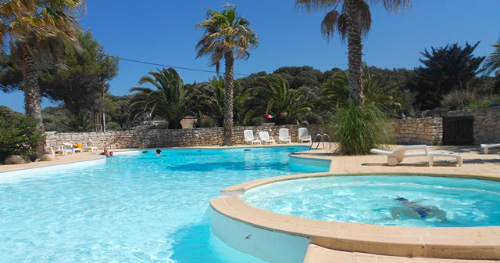 Cette image évoque une oasis de paix où on peut se détendre sous le ciel bleu, entouré de palmiers et de la douce chaleur du soleil, idéale pour des vacances mémorables et relaxantes en plein air.