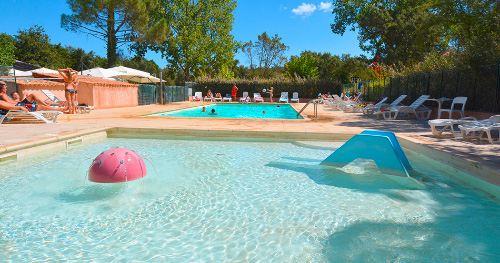 Cette image évoque une ambiance estivale joyeuse autour d'une piscine familiale, où petits et grands se rassemblent pour profiter d'un moment de détente et de convivialité sous le soleil éclatant.