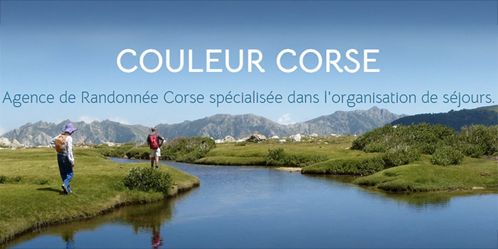 Cette image capture deux randonneurs en Corse, entourés de montagnes et d'une nature luxuriante, reflet d'un ciel limpide pour un moment paisible et magique.