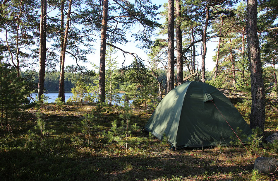 L'image capture l'apaisement et la beauté naturelle d'un camping au bord d'un lac, invitant à la déconnexion et à l'émerveillement devant la majesté de la nature, idéale pour les randonneurs et les explorateurs.