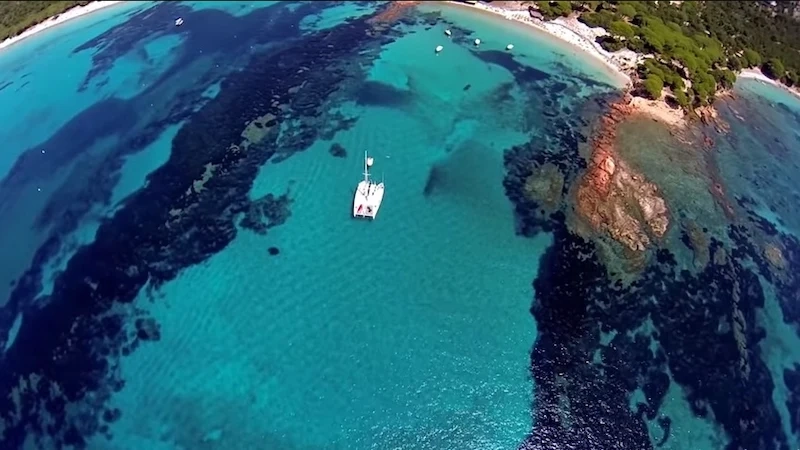 Bateau flottant sur les eaux cristallines des îles Lavezzi, Corse du Sud