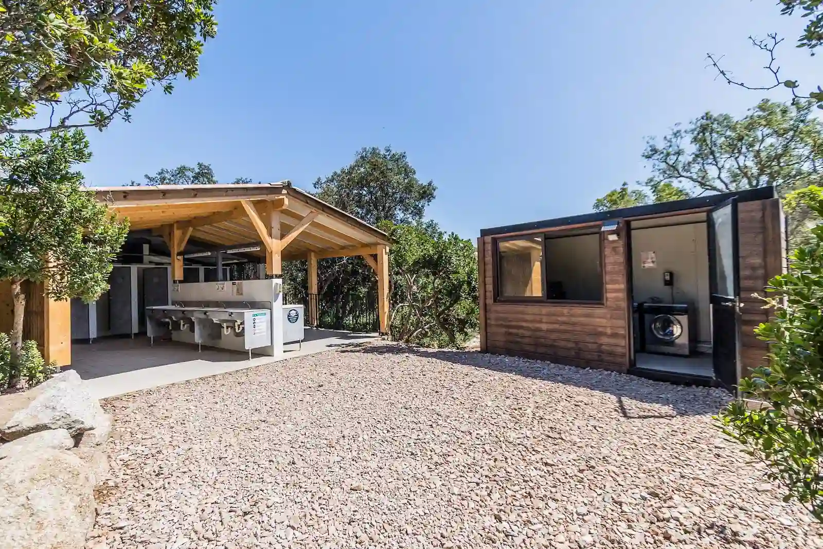 Sanitaires modernes et espace buanderie avec lave-linge au Camping Le Damier en Corse.