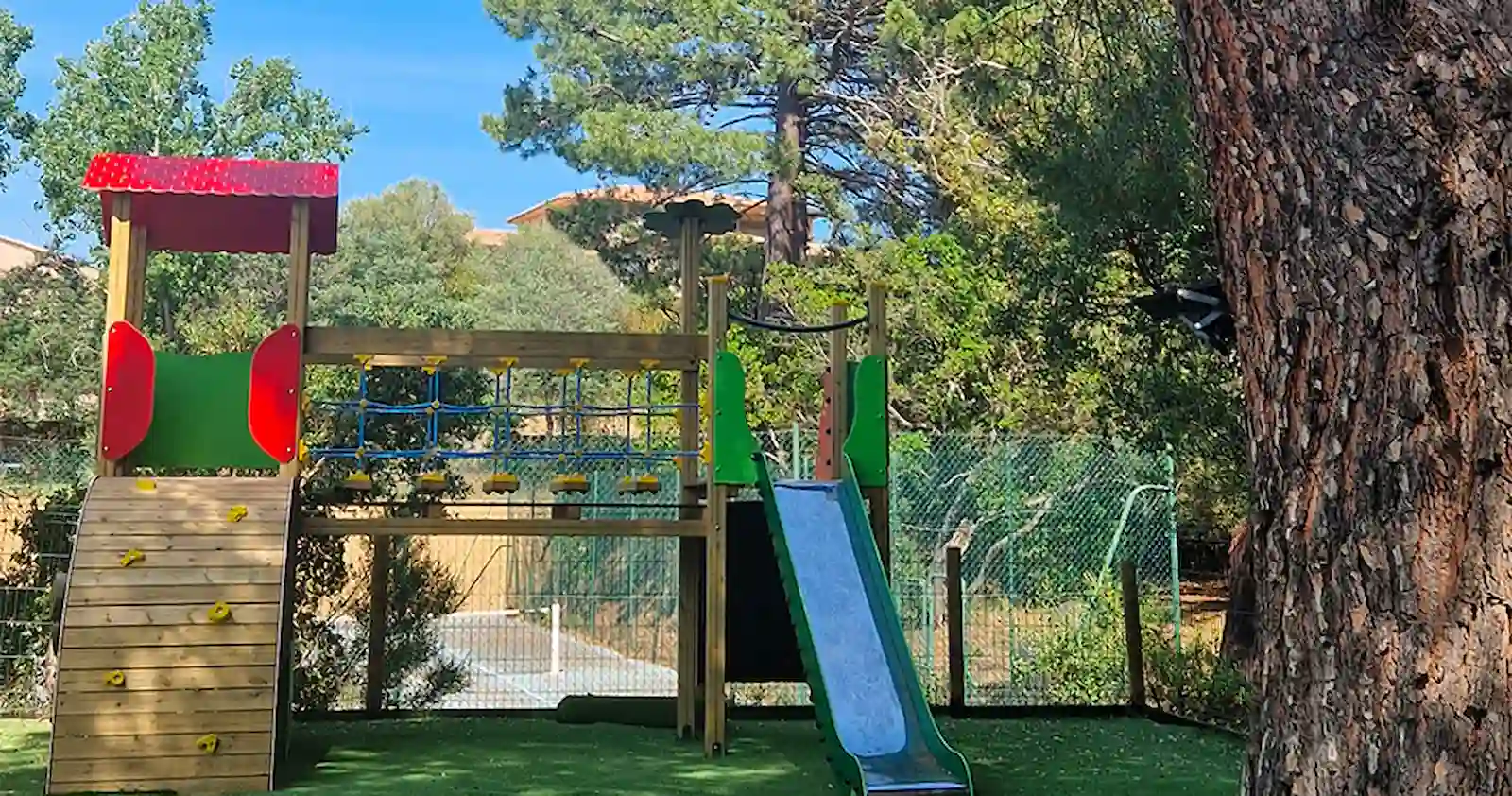 Aire de jeux sécurisée en bois pour enfants au Camping U Pinarellu.