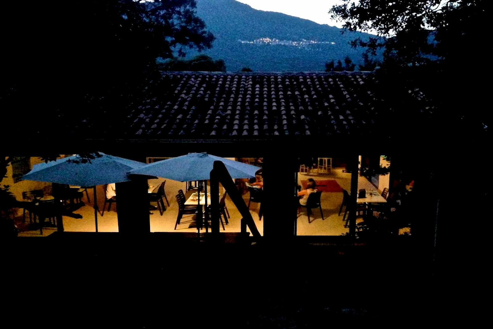 Terrasse du Camping Milella avec vue panoramique sur les montagnes corses au crépuscule.