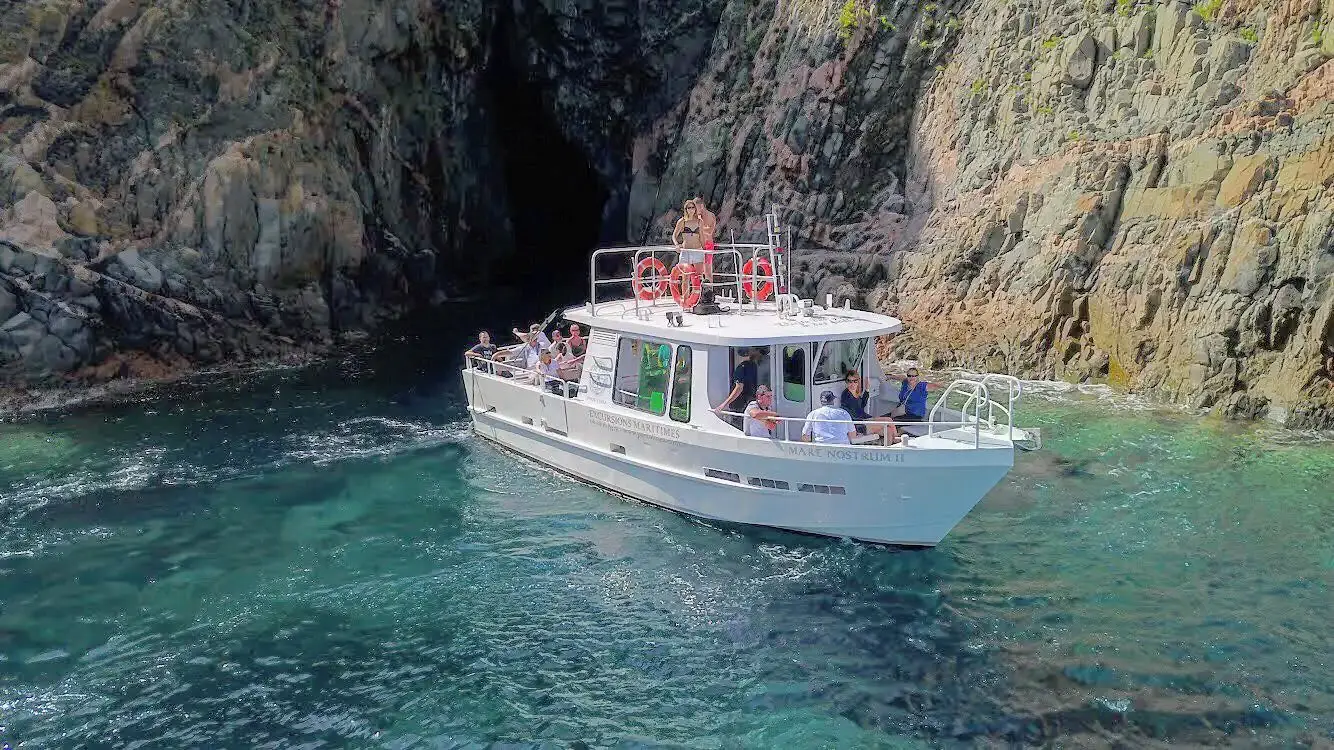 Passagers profitant d'une excursion en mer sur le bateau Mare Nostrum II près des falaises de Corse.