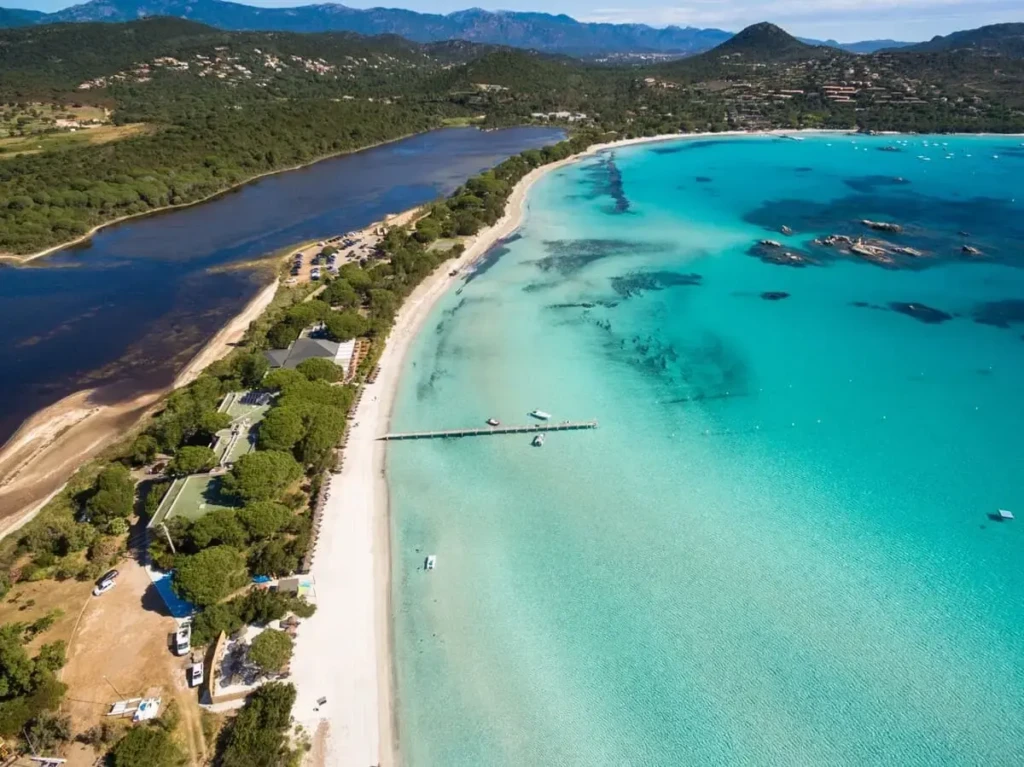 plage-de-santa-giulia-vue-du-ciel-corse-du-sud Vue du ciel de la baie de Santa Giulia avec son ponton emblématique, son eau cristalline peu profonde et son sable blanc.